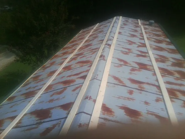 Rusted metal roof panels with new wood purlins before replacement — Storm Damage Roof Repair in Barnesville by Roofing Brothers
