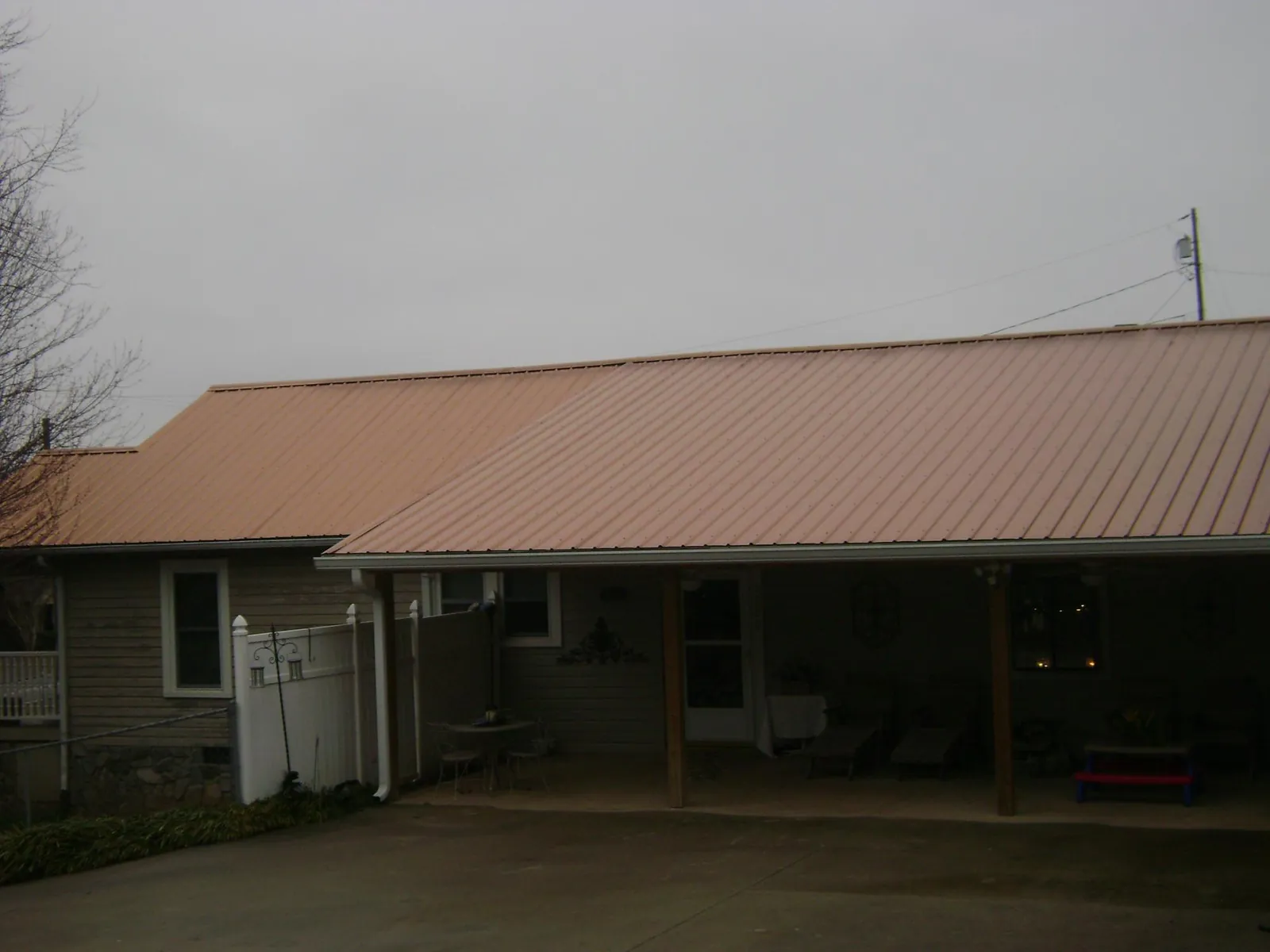 Copper toned metal roof over a wide covered patio in Barnesville
